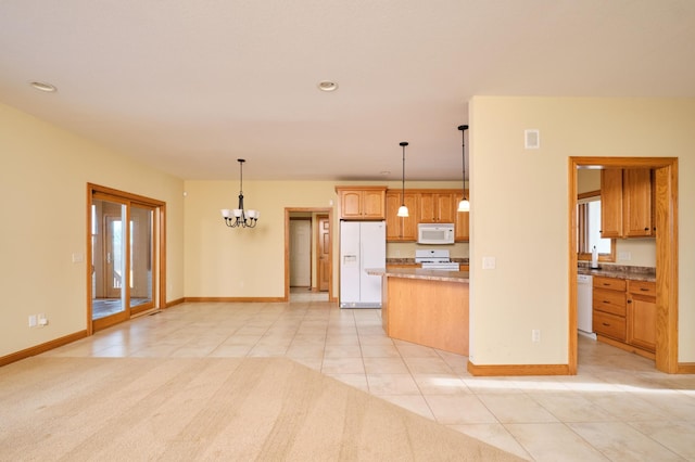 kitchen with a wealth of natural light, hanging light fixtures, a notable chandelier, white appliances, and light tile patterned floors