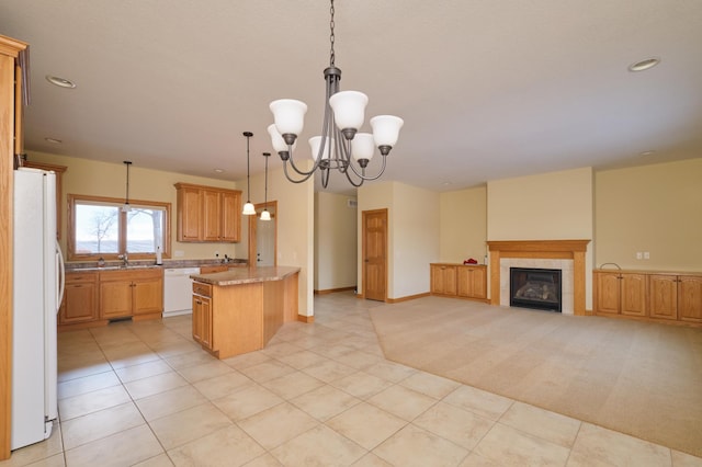 kitchen featuring white appliances, a tile fireplace, decorative light fixtures, light colored carpet, and a chandelier