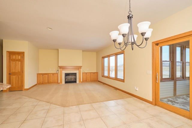 unfurnished living room featuring light tile patterned flooring, an inviting chandelier, and a tiled fireplace