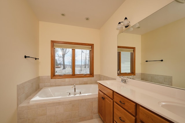 bathroom featuring vanity and tiled bath