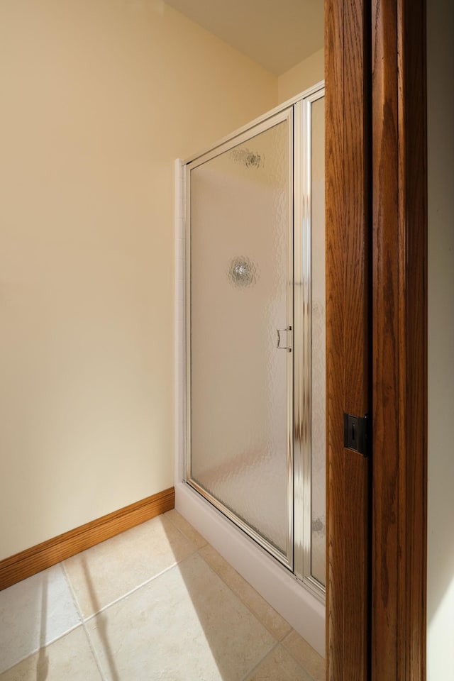 bathroom with tile patterned flooring and a shower with shower door