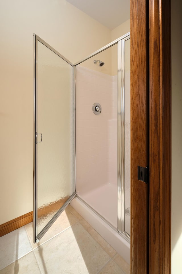 bathroom with tile patterned flooring and a shower with shower door