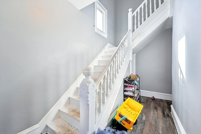 stairway with wood finished floors and baseboards