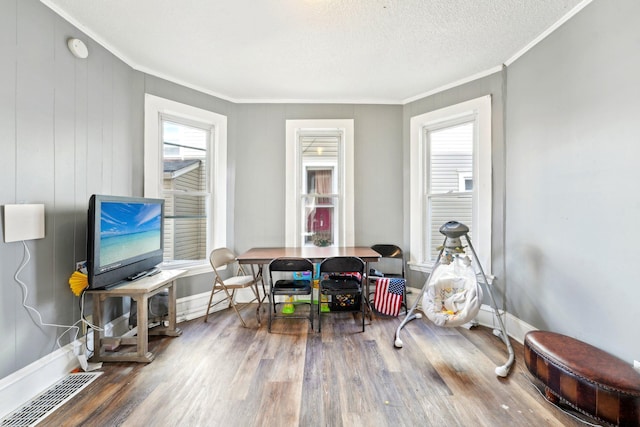 rec room with baseboards, wood finished floors, visible vents, and crown molding