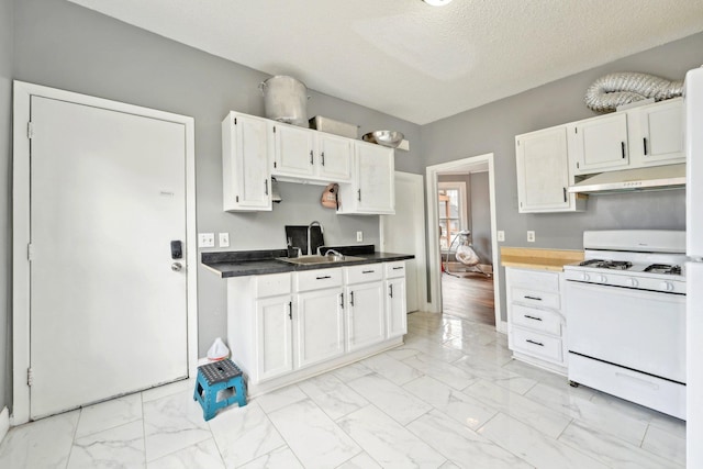 kitchen featuring a textured ceiling, under cabinet range hood, white range with gas stovetop, white cabinets, and marble finish floor