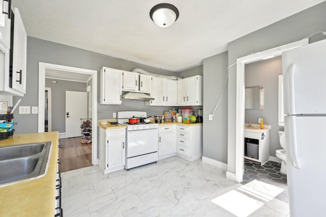 kitchen featuring marble finish floor, light countertops, white appliances, under cabinet range hood, and baseboards