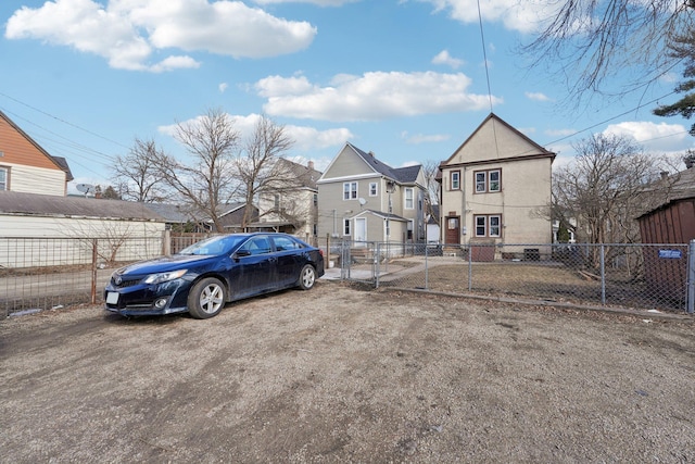 view of car parking with fence and a residential view