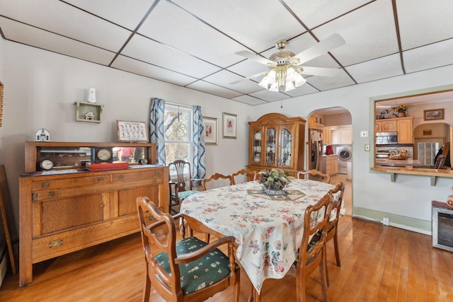 dining room featuring light hardwood / wood-style floors, a paneled ceiling, ceiling fan, and washer / clothes dryer