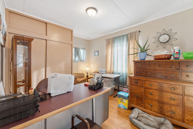 home office with crown molding and light wood-type flooring