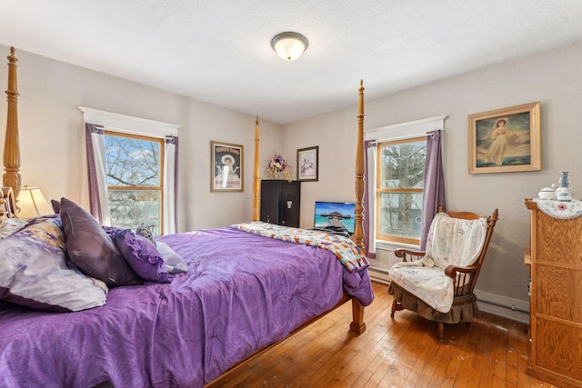 bedroom with a baseboard radiator and wood-type flooring