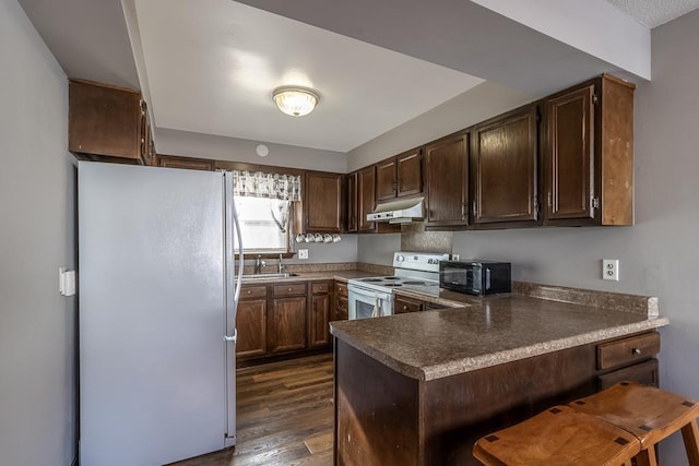 kitchen featuring kitchen peninsula, white electric range, dark hardwood / wood-style flooring, stainless steel refrigerator, and sink