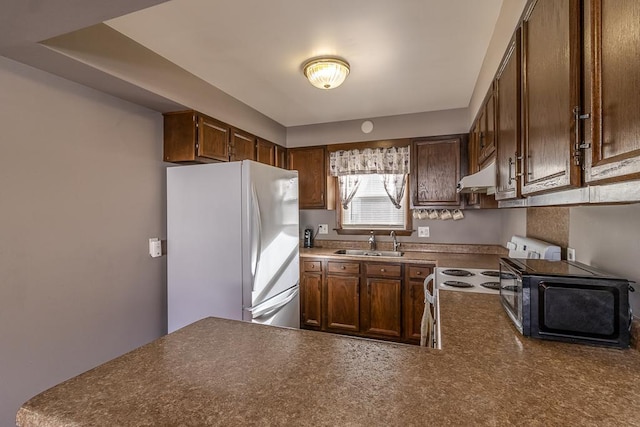 kitchen featuring fridge, kitchen peninsula, sink, and stove