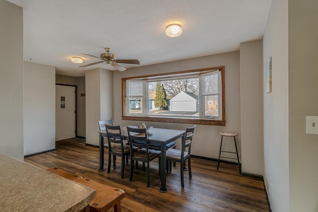 dining room with ceiling fan and dark hardwood / wood-style flooring