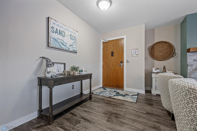 foyer entrance with a textured ceiling and dark hardwood / wood-style flooring