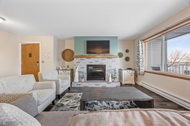 living room featuring a brick fireplace, a baseboard radiator, a textured ceiling, and dark hardwood / wood-style flooring