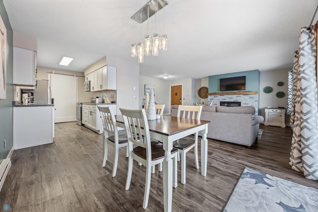 dining space featuring a textured ceiling, an inviting chandelier, and dark hardwood / wood-style flooring