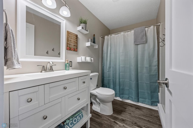 bathroom with toilet, vanity, a textured ceiling, and hardwood / wood-style flooring