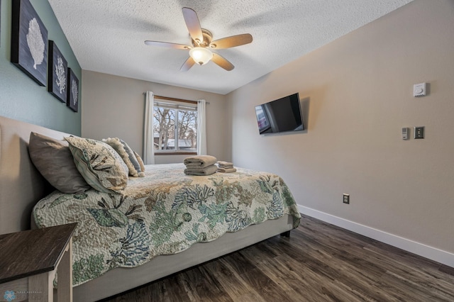 bedroom with a textured ceiling, ceiling fan, and dark hardwood / wood-style floors