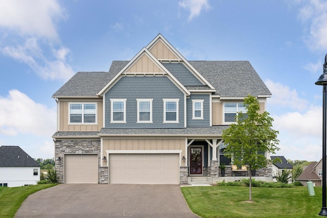 craftsman-style house with an attached garage, stone siding, aphalt driveway, board and batten siding, and a front lawn