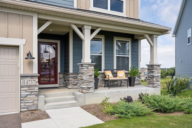view of exterior entry featuring a porch, board and batten siding, and stone siding