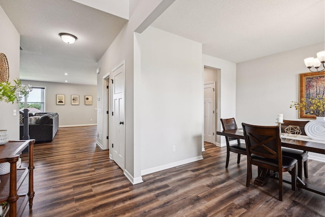 dining space featuring baseboards, a chandelier, and dark wood-style floors