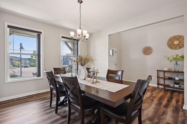 dining area with a chandelier, dark wood-type flooring, and baseboards