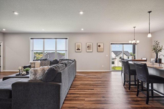 living room with a chandelier, baseboards, dark wood finished floors, and recessed lighting