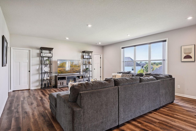 living room featuring recessed lighting, baseboards, a textured ceiling, and dark wood finished floors