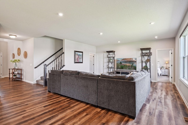 living area featuring dark wood-type flooring, baseboards, stairway, and recessed lighting