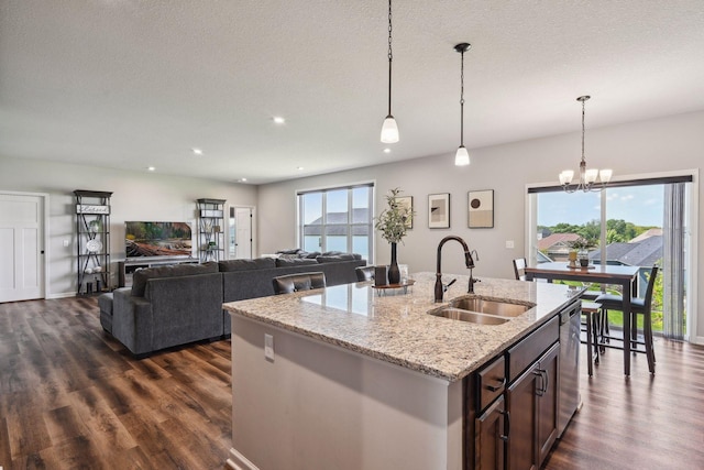 kitchen featuring a healthy amount of sunlight, dishwasher, a sink, and dark wood finished floors