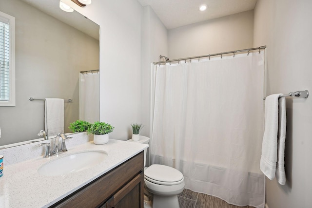 full bath with shower / tub combo with curtain, vanity, toilet, and a healthy amount of sunlight