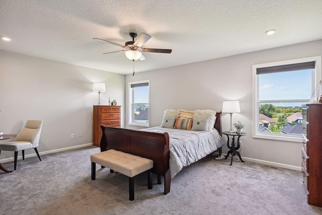 bedroom featuring ceiling fan, baseboards, multiple windows, and carpet floors