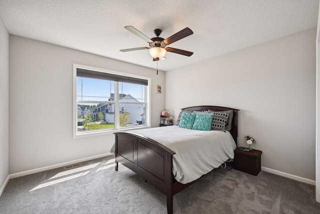 carpeted bedroom featuring visible vents, baseboards, a ceiling fan, and a textured ceiling