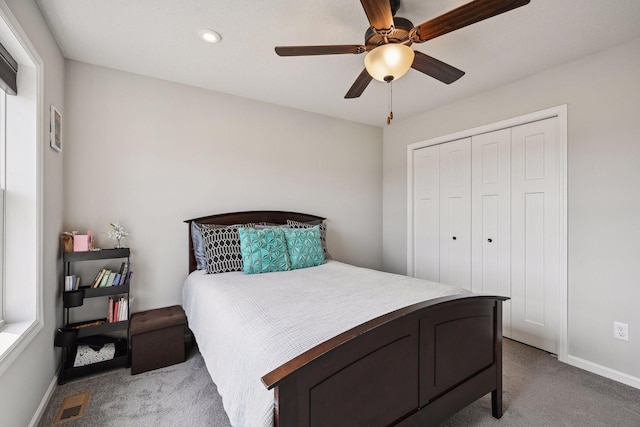 carpeted bedroom with a closet, ceiling fan, baseboards, and visible vents