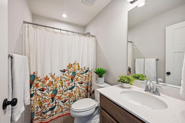 full bathroom featuring a textured ceiling, vanity, a shower with curtain, visible vents, and toilet