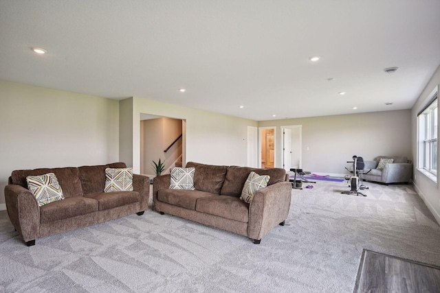 carpeted living room with recessed lighting, baseboards, and stairway