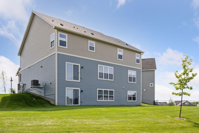 rear view of property featuring a yard and central AC unit