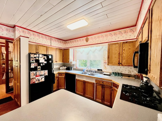 kitchen with black appliances, kitchen peninsula, wood ceiling, and sink