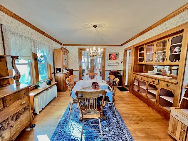 dining room featuring radiator, a chandelier, crown molding, and light hardwood / wood-style floors