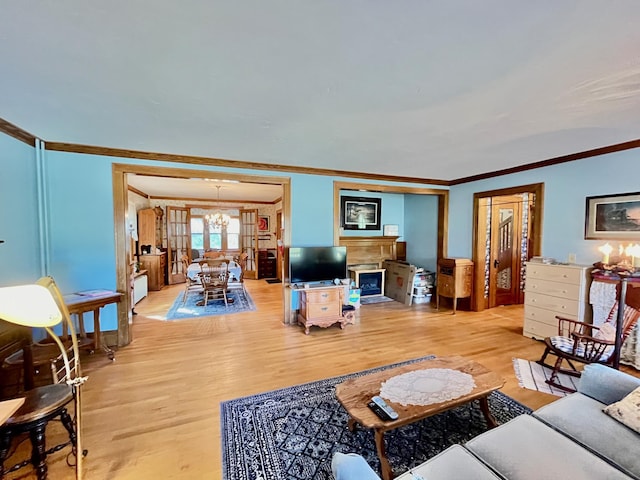 living room with a chandelier, light hardwood / wood-style flooring, and ornamental molding