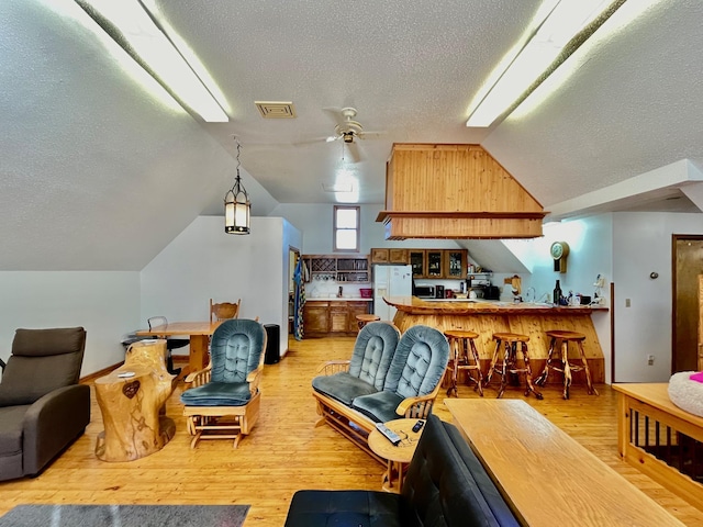 interior space featuring wood-type flooring, a textured ceiling, ceiling fan, and lofted ceiling