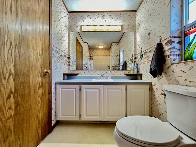 bathroom with vanity, toilet, and ornamental molding