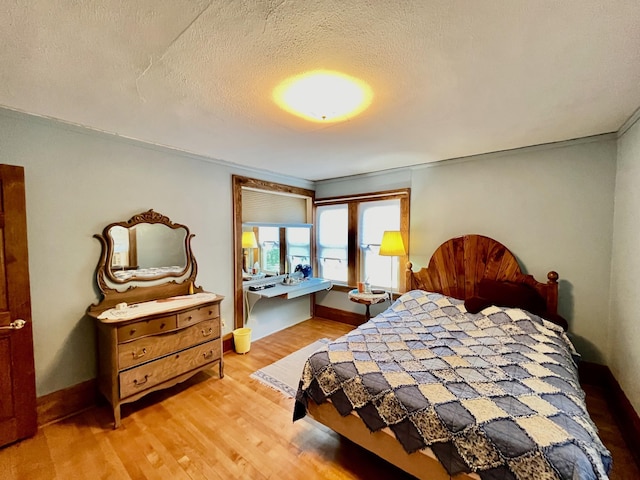 bedroom featuring a textured ceiling and light hardwood / wood-style flooring