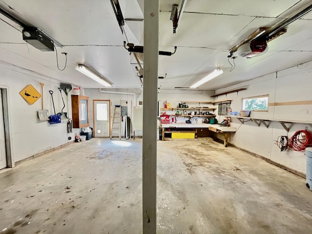 garage featuring a workshop area, electric panel, and a garage door opener