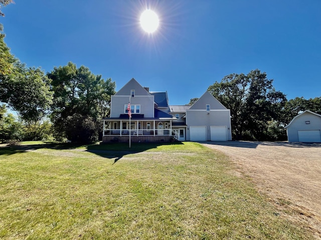 view of front of property with covered porch, a garage, and a front lawn