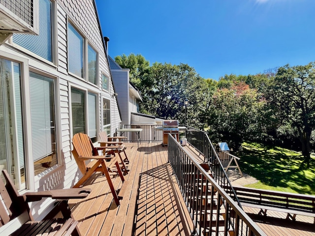 wooden terrace with area for grilling and a yard