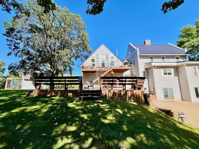 rear view of house with a yard and a wooden deck