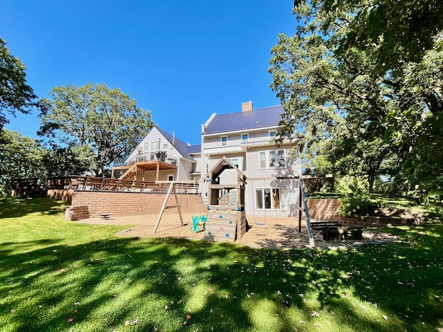 back of property featuring a playground and a yard