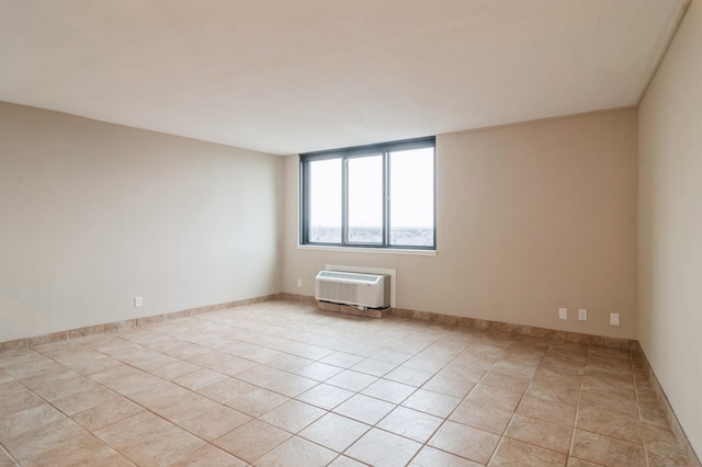 empty room featuring a wall unit AC and light tile patterned floors