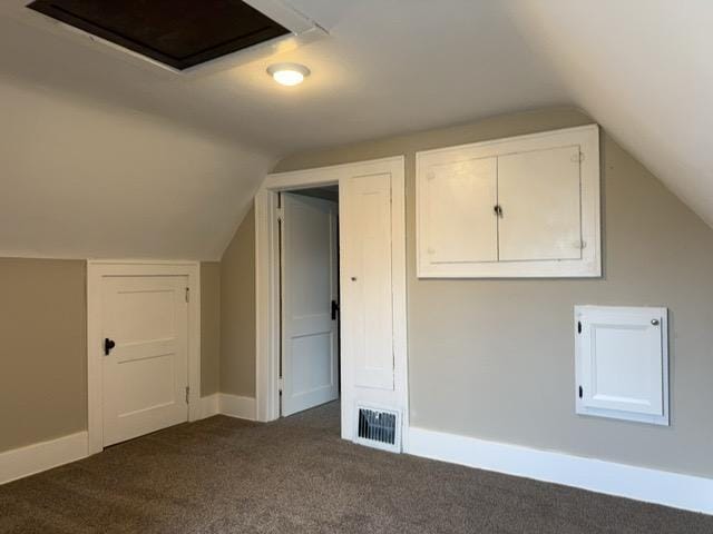 bonus room featuring dark colored carpet and lofted ceiling